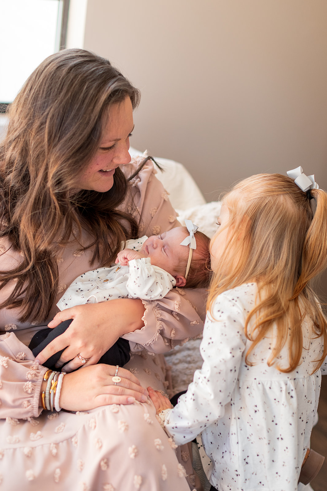 Mom and her girls cuddled up together in home during photo session with a full-service photographer