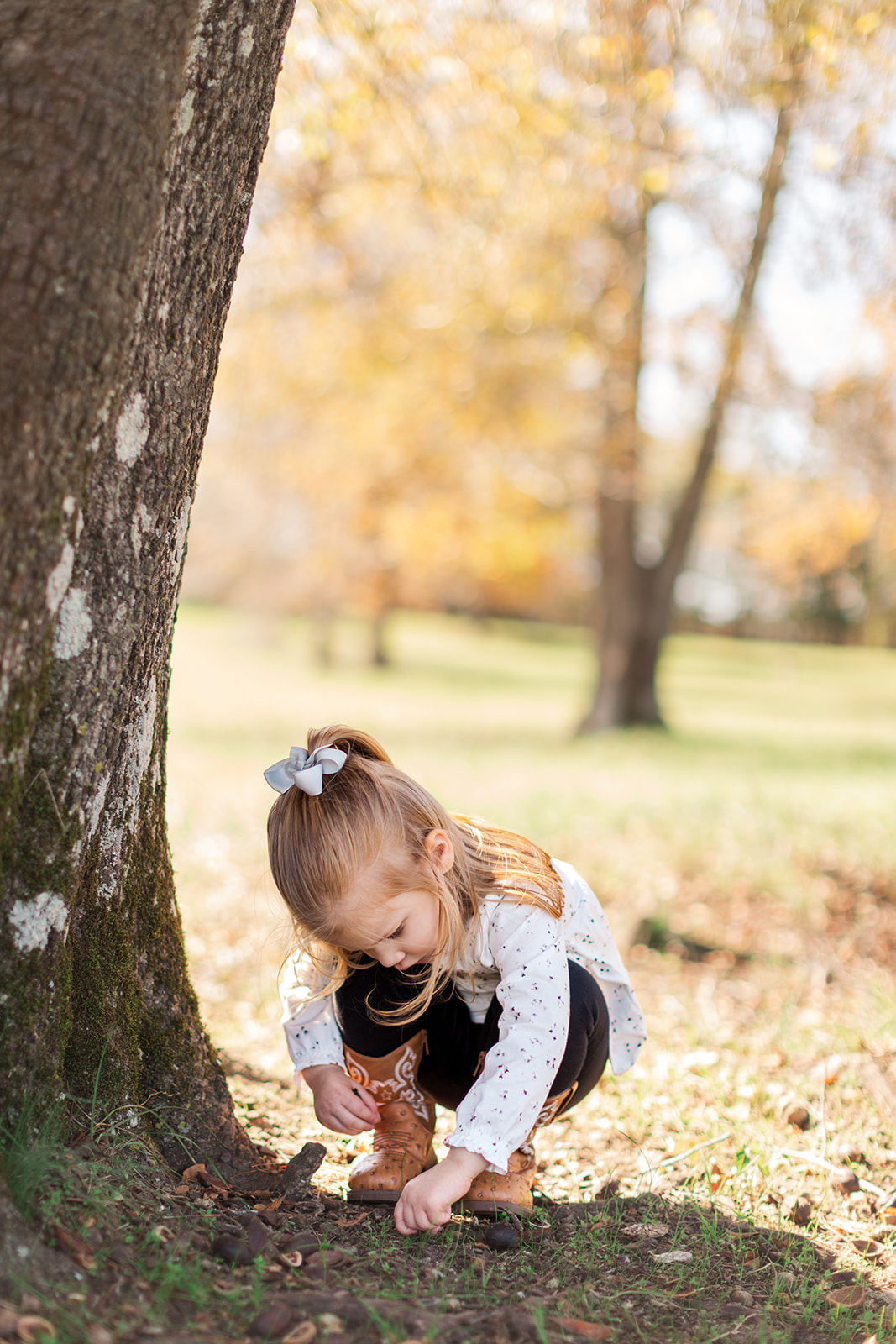 Older sister candid photo of her playing in dirt during family photo session near Charlotte, NC