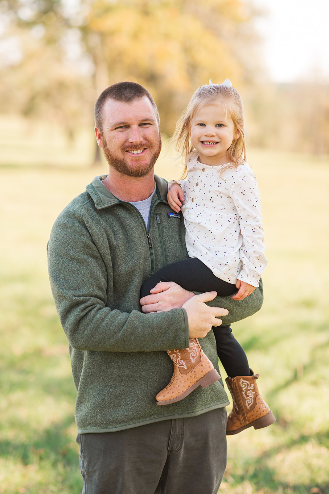 Dad and big sister smiling at the camera during family photo session.
