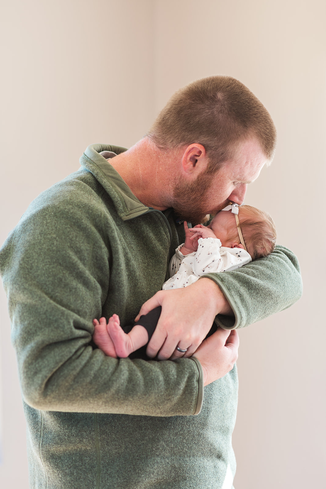 Dad holding new daughter in his arm - natural light photography