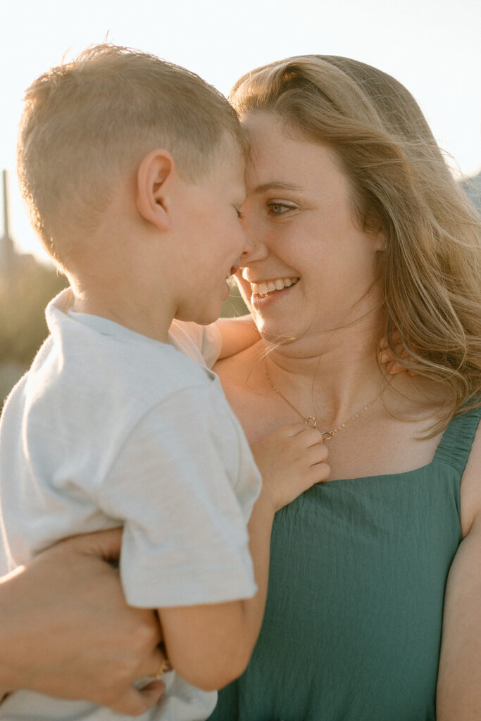Golden hour light glowing behind the family on the dunes