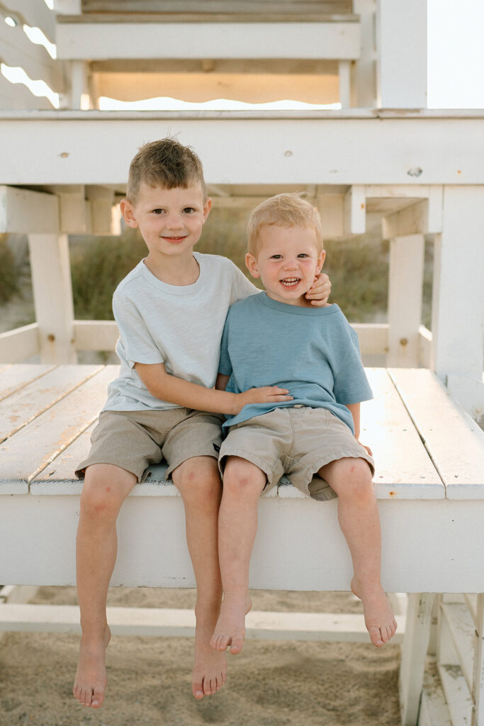 brothers sitting on lifeguard stand during family photo session