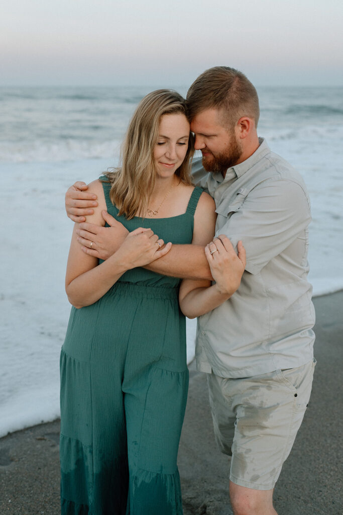 Mom and dad embracing as waves roll in