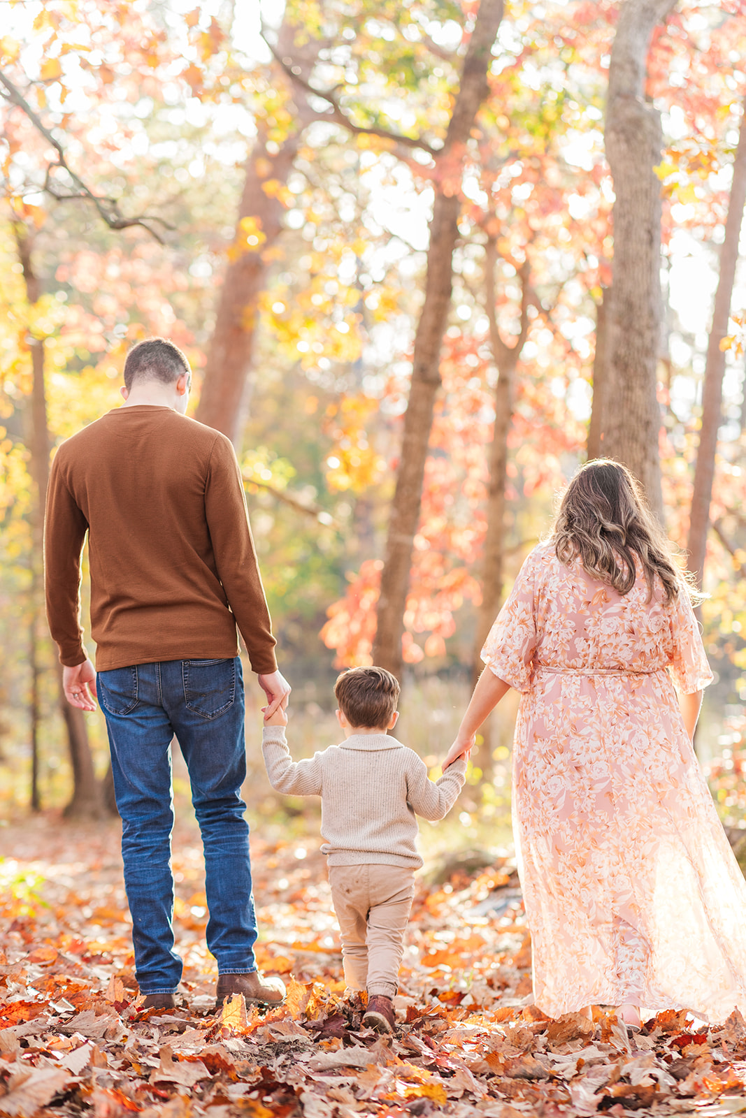 Barker family holding hands and walking on a rustic path at Murray’s Mill historic site
