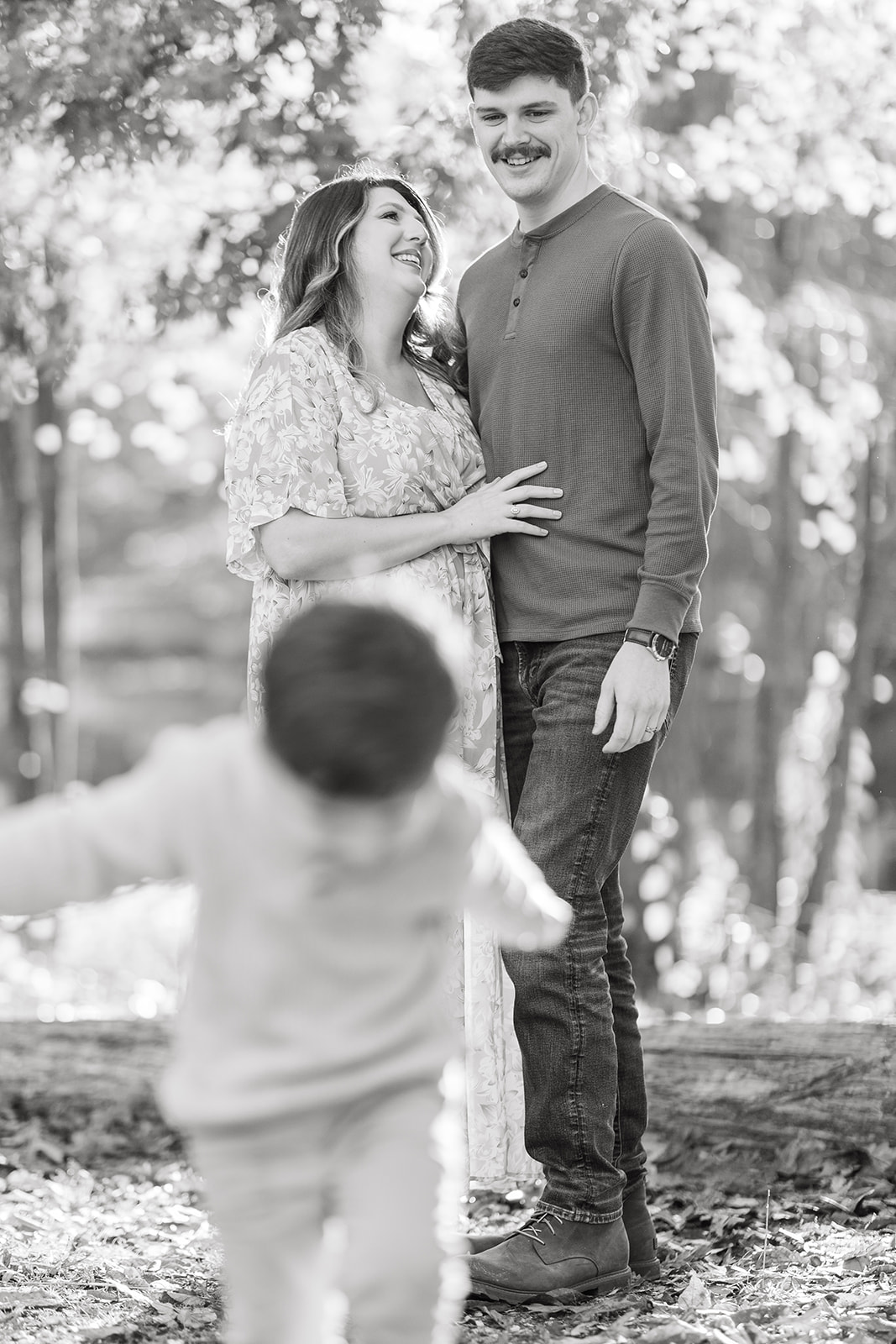 Barker family candid laugh under tall trees in early morning light