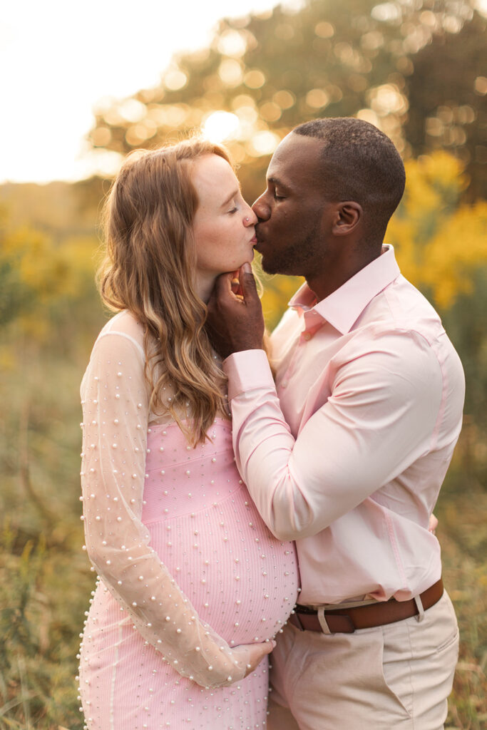 couple kissing with soft natural golden light behind 