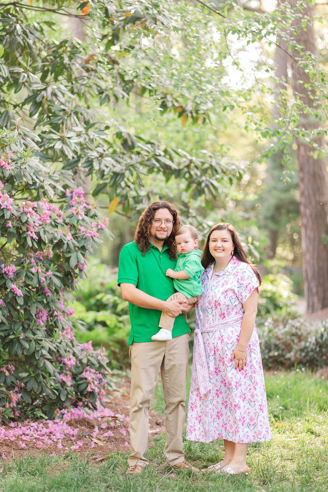 Family of three standing by a blossoming tree at Glencairn Garden