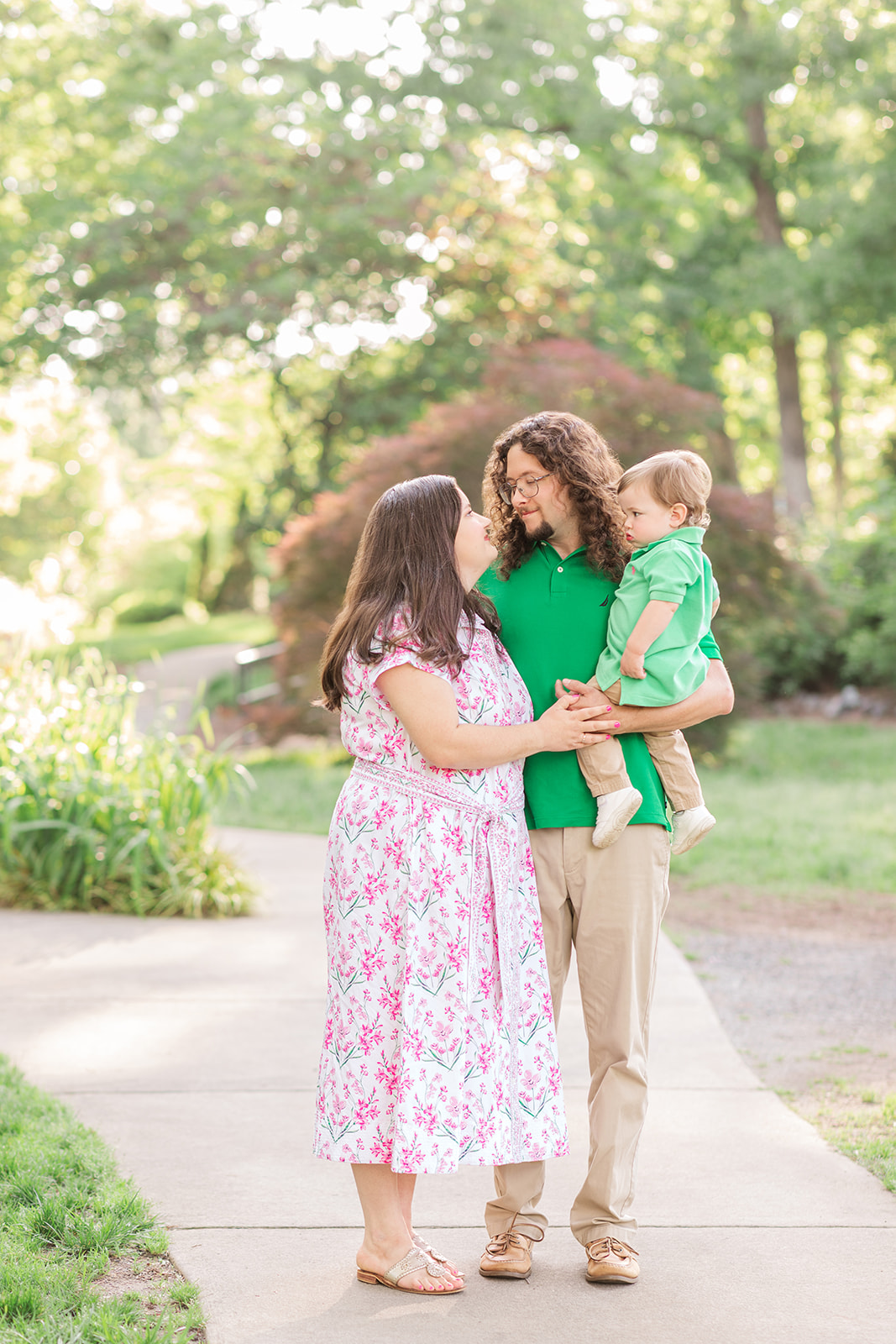 Family of three looking at each other in Glencarin Garden in Rock Hill, SC.