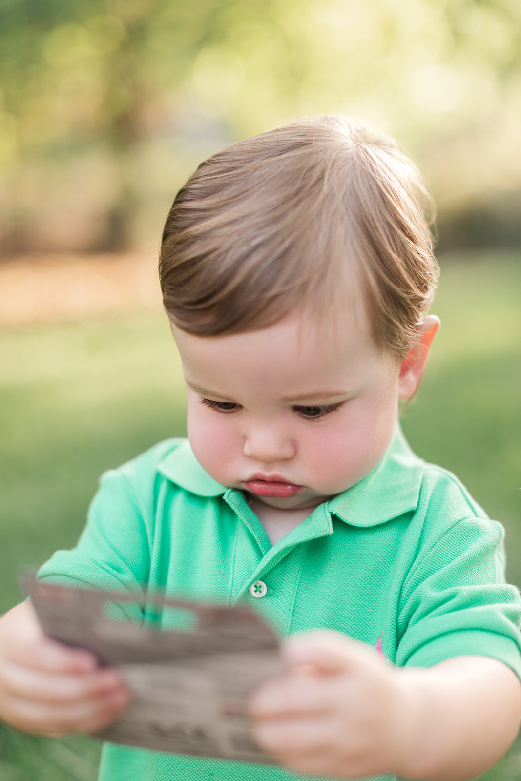 One-year-old Jack walking near blooming flowers during spring family photo session