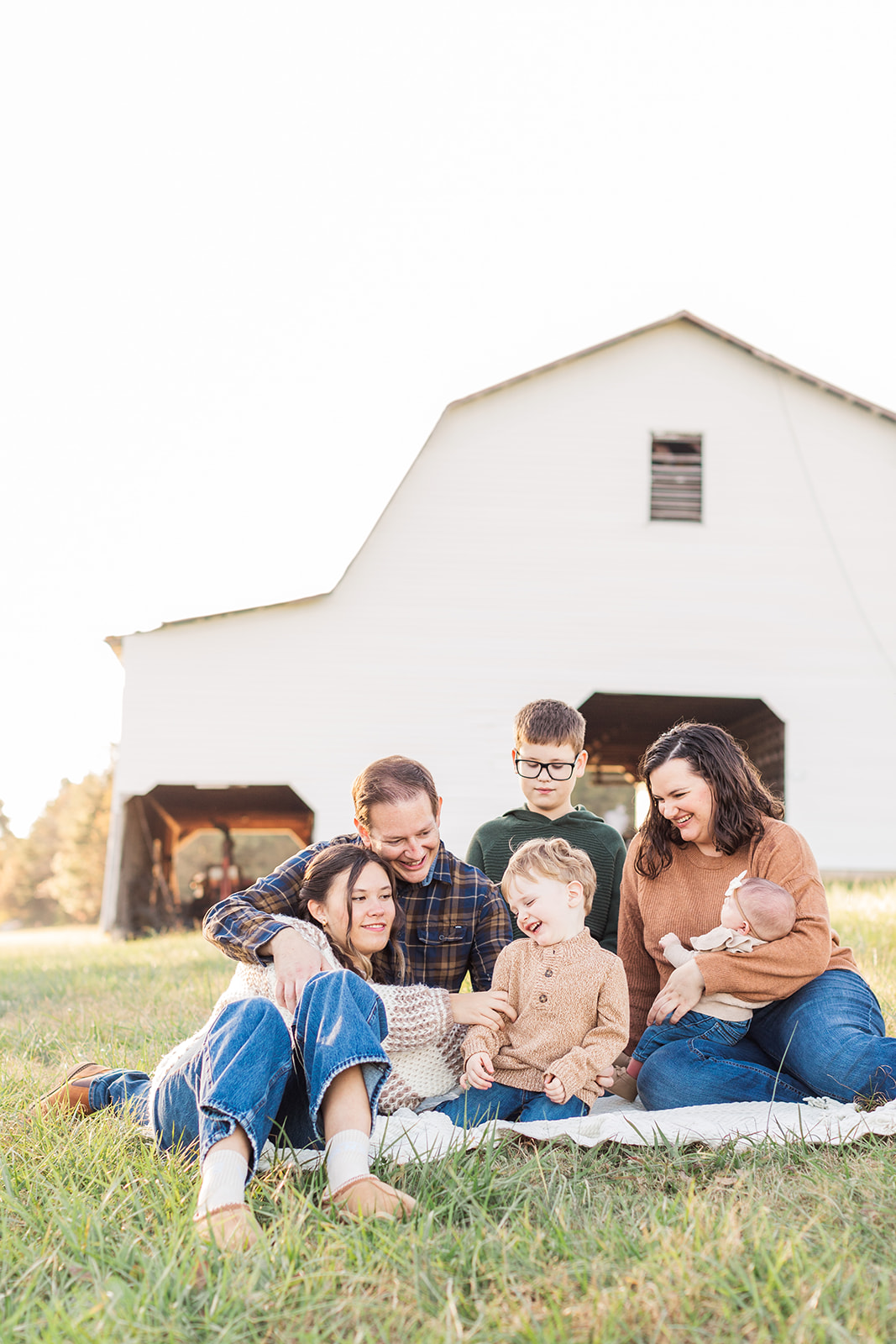 Family sitting on a blanket in front of the old mill
