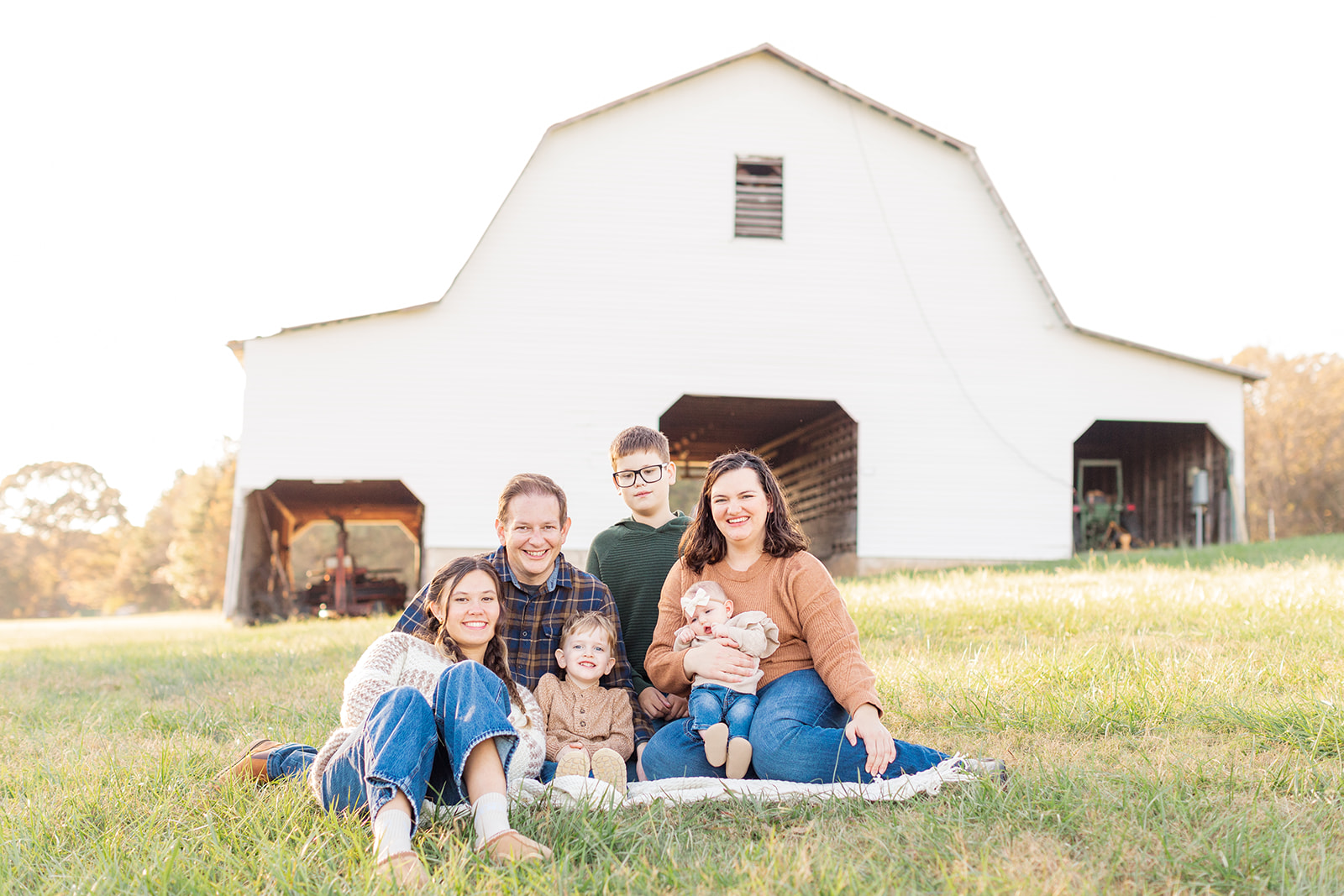 Family sitting on a blanket in front of the old mill