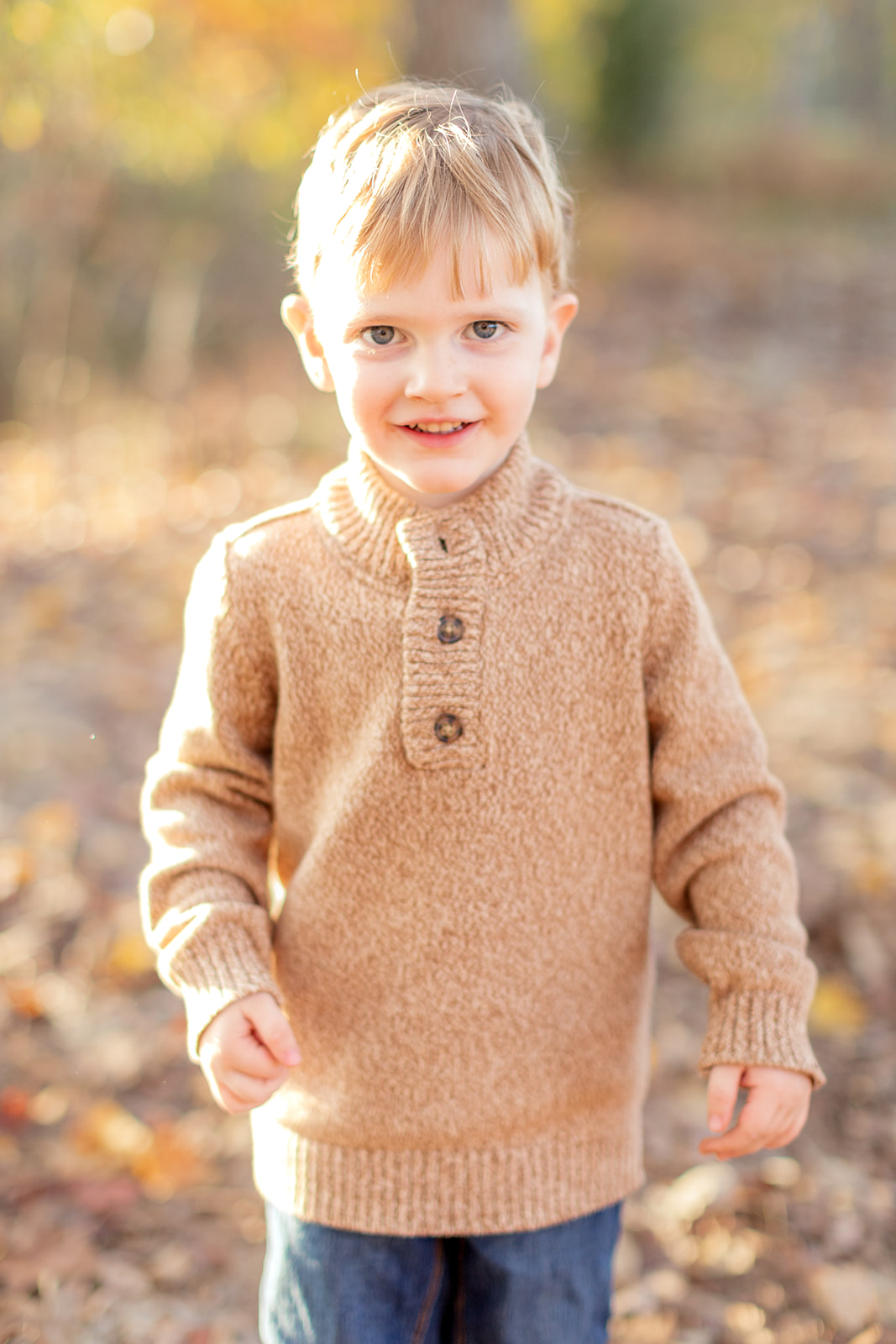 Close-up of big brother smiling with trees in the background