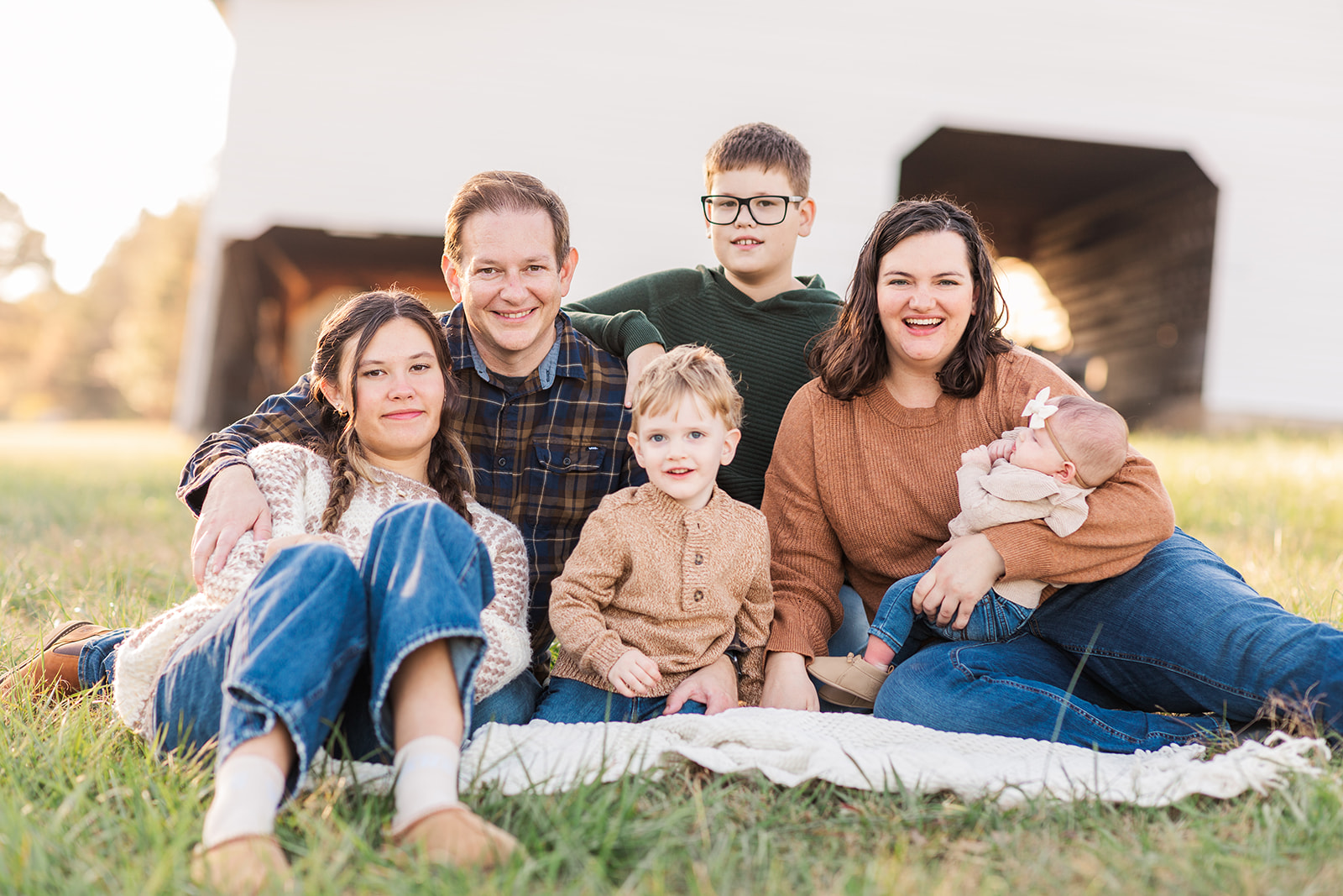 Family sitting on a blanket in front of the old mill