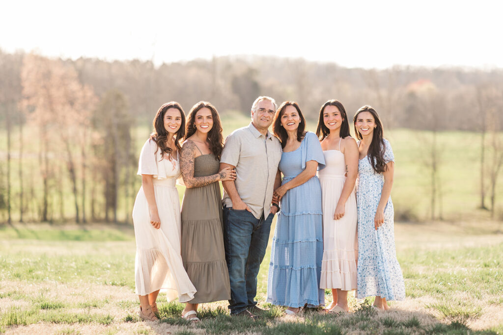 Snider family group photo with coordinated outfits in soft evening light