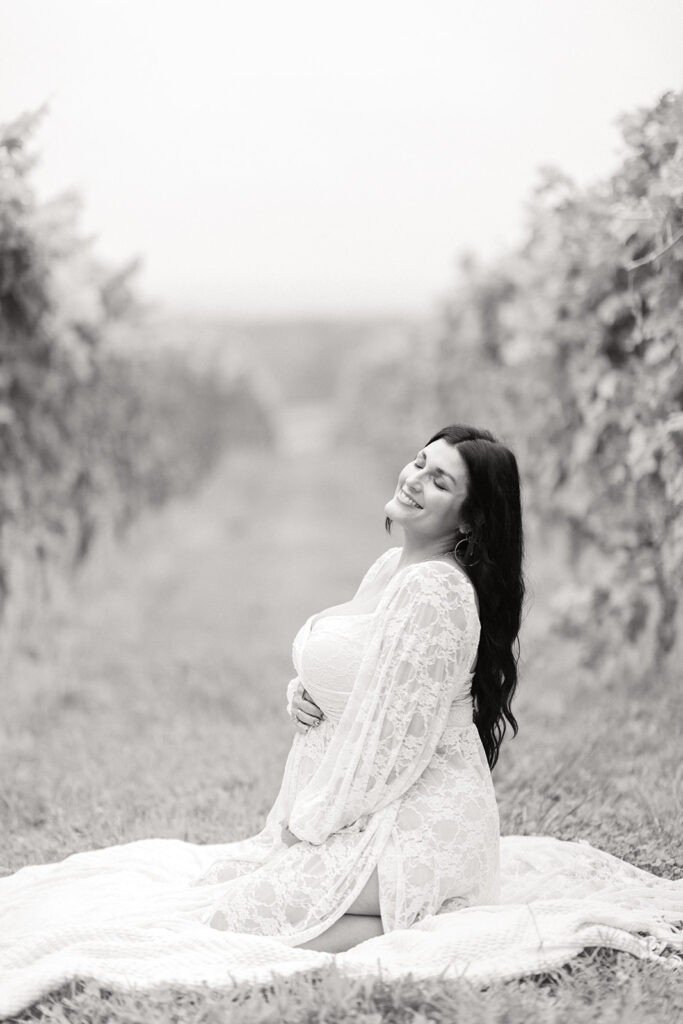 Hands on baby bump with vineyard in background