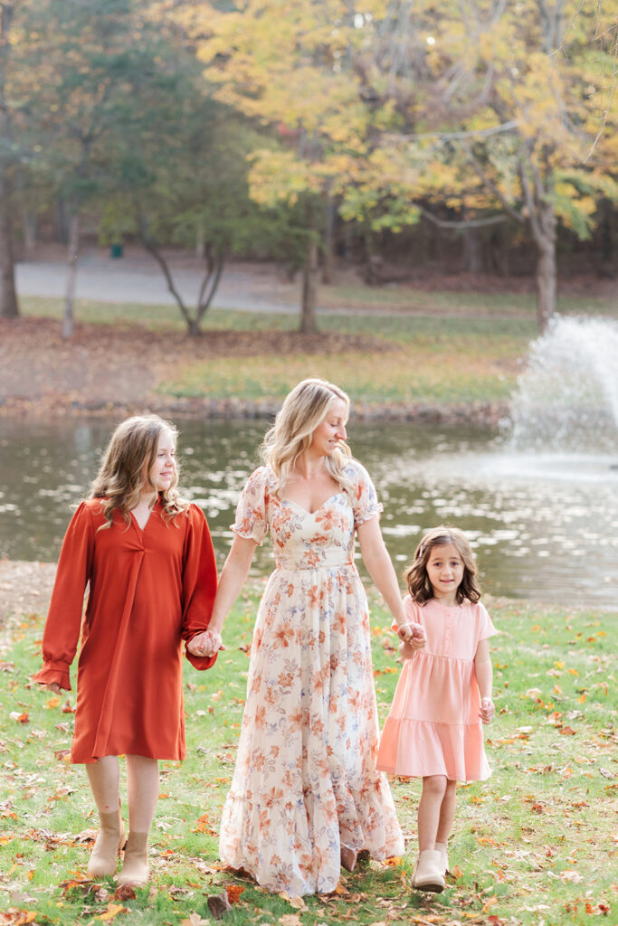 Mom and daughter smiling under golden trees in Statesville