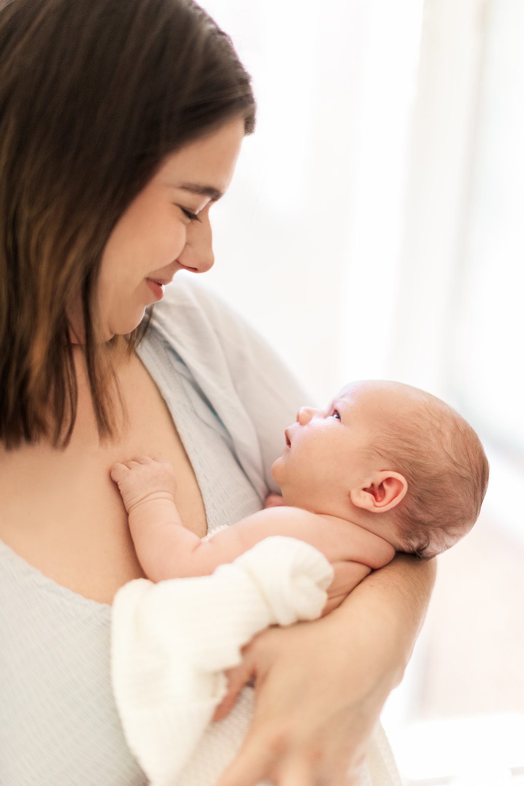 Mother holding newborn son during in-home lifestyle session in Statesville, NC