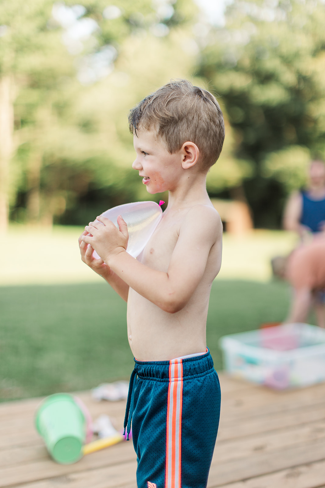 Joyful Ryder holding a water balloon and flashing a big smile