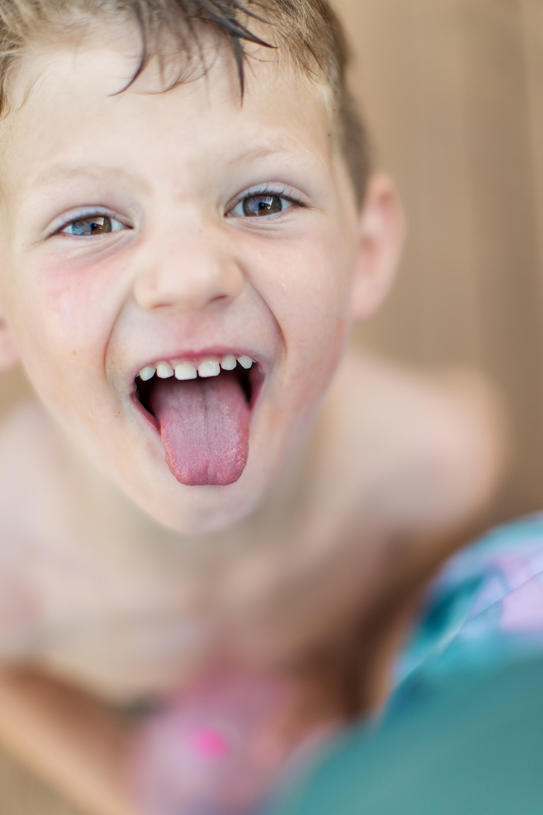 Four-year-old Ryder sticking out his tongue while playing outside