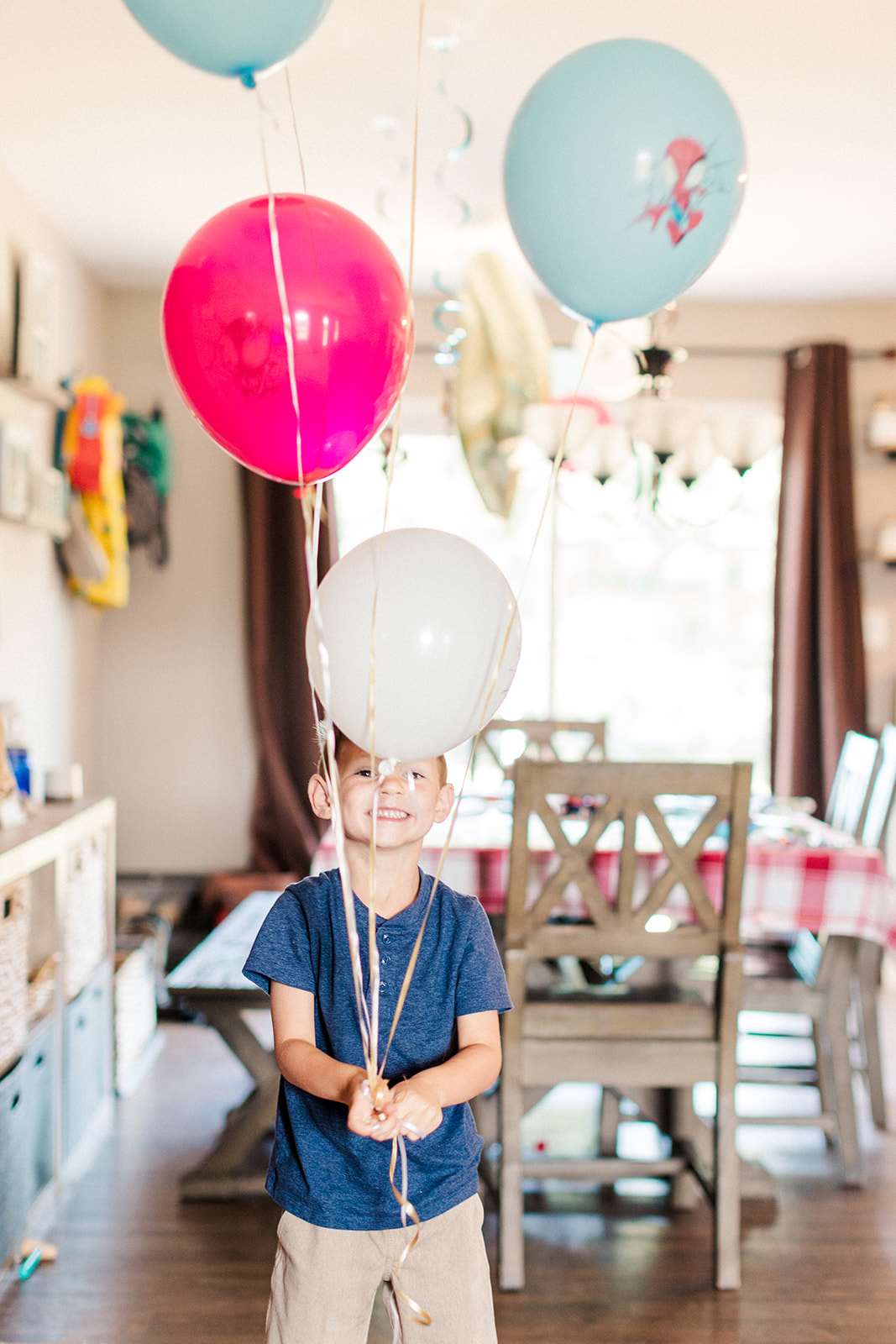 Birthday boy Ryder holding colorful balloons and smiling