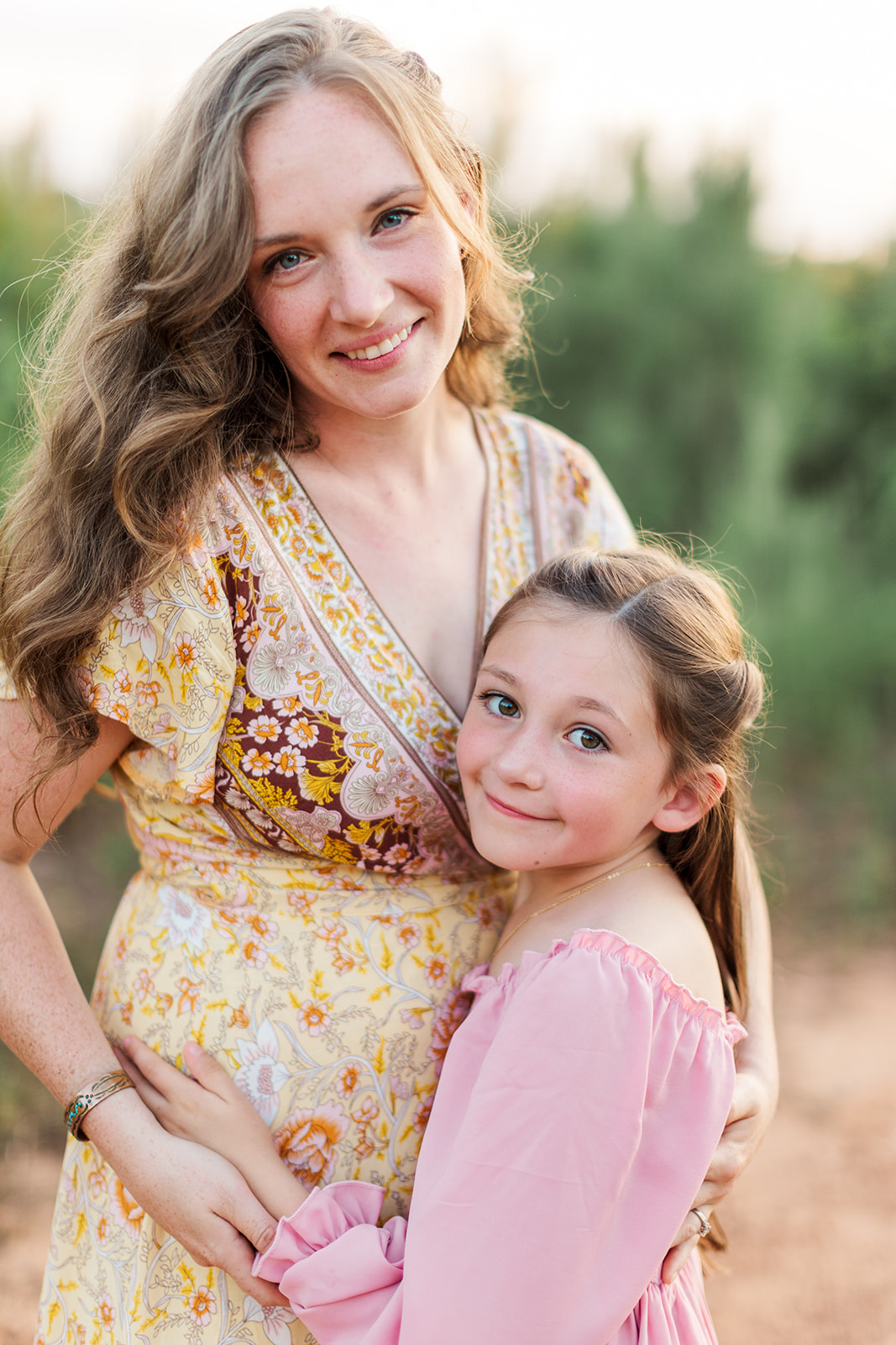 mom and daughter embracing during family photo session on their property
