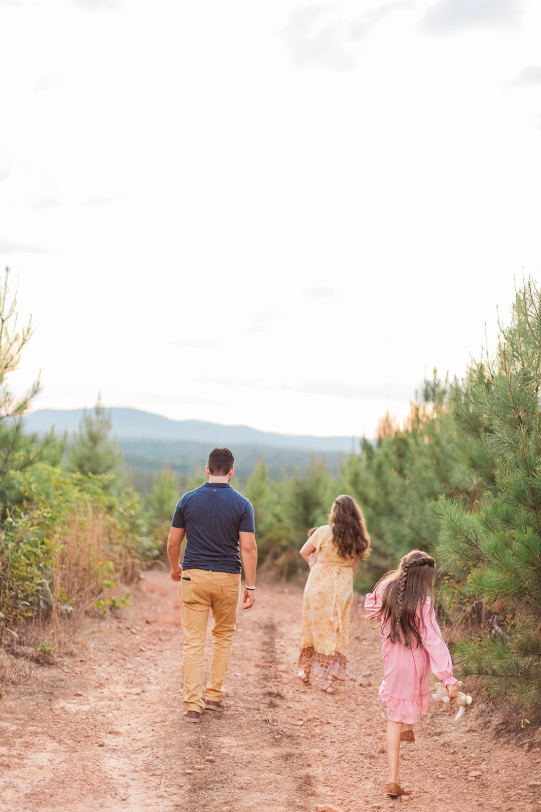 family walking into the sunset during family photo session