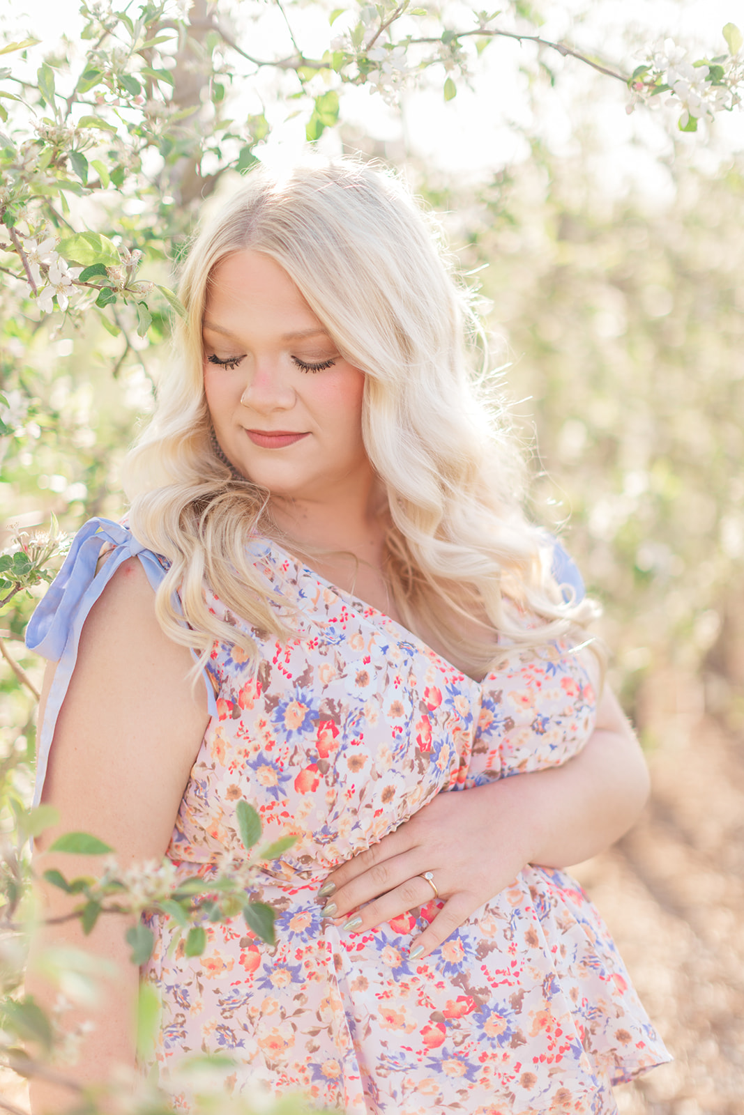 Expectant mom surrounded by blooming white flowers