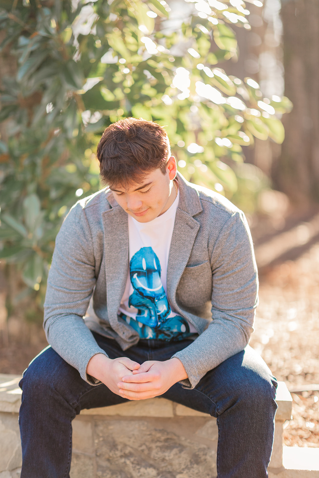 Thoughtful senior portrait on a stone bench on family property in Statesville NC