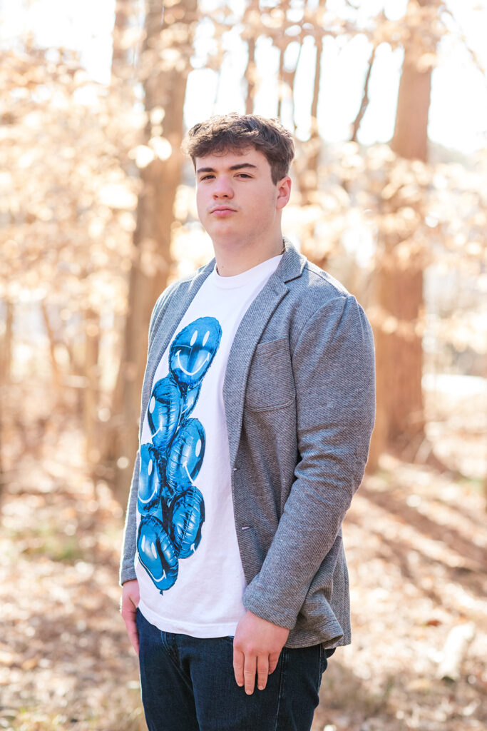Close-up of senior guy with soft sunlight through trees