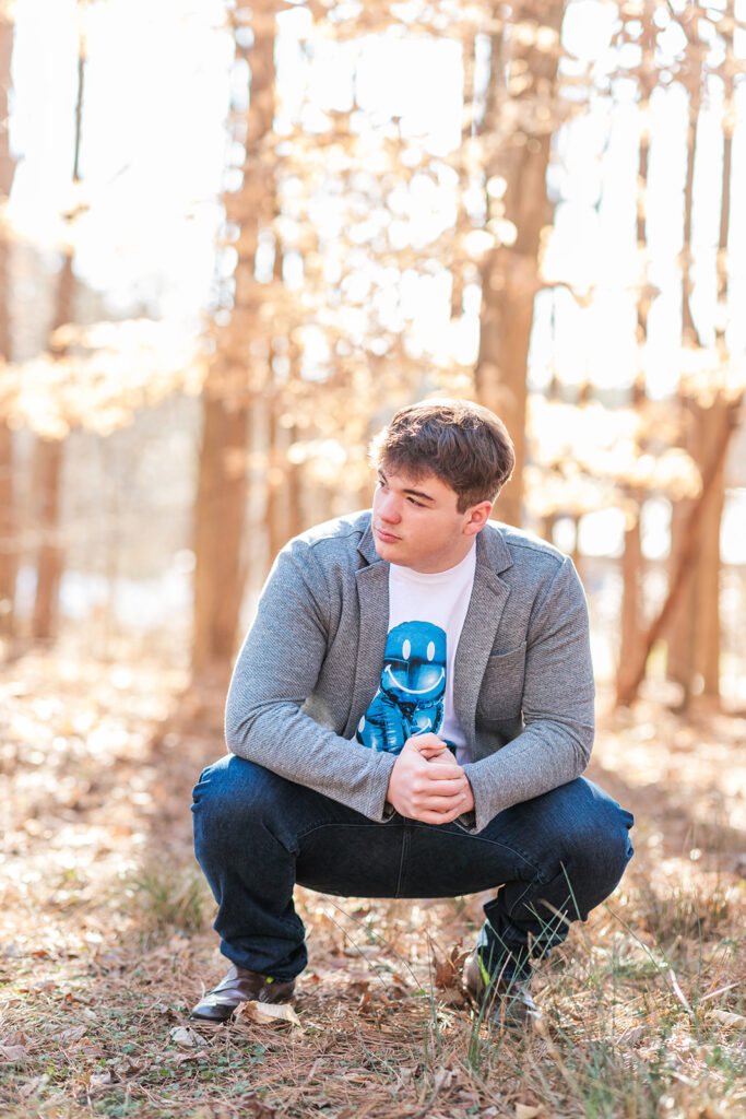 Laid-back senior pose in front of rustic forested backdrop
