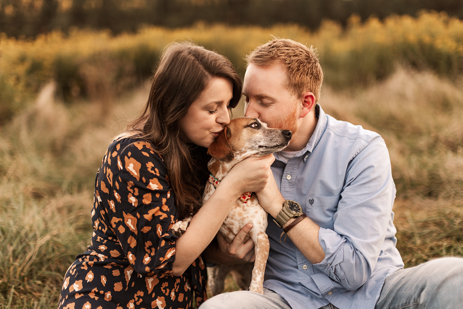 Family kissing dog in fall field near Charlotte, NC.