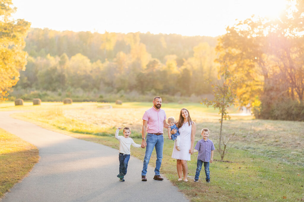 Family of five walking along path at Fisher Farm North Carolina at Golden Hour for their mini session. 