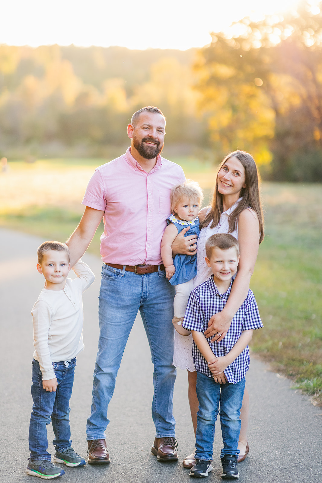 Family of five looking at camera at golden hour at Fisher Farm in Davidson, NC.