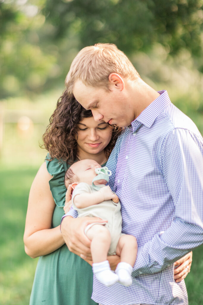 Parents looking at newborn baby in morning light near Salisbury, NC.