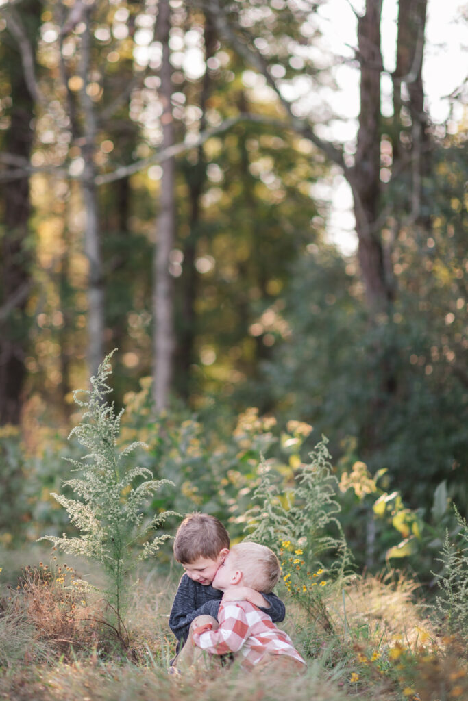 Toddler brothers in a field in a fall. 