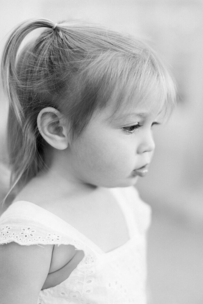 Close up Black-and-white side portrait of a little girl in pigtails.  