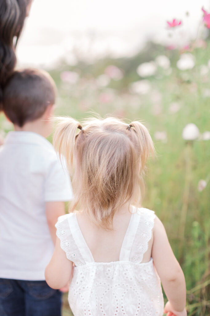 Little girl in pigtails walking in the wildflowers at Fleurish Greenhouse in Taylorsville, NC. 