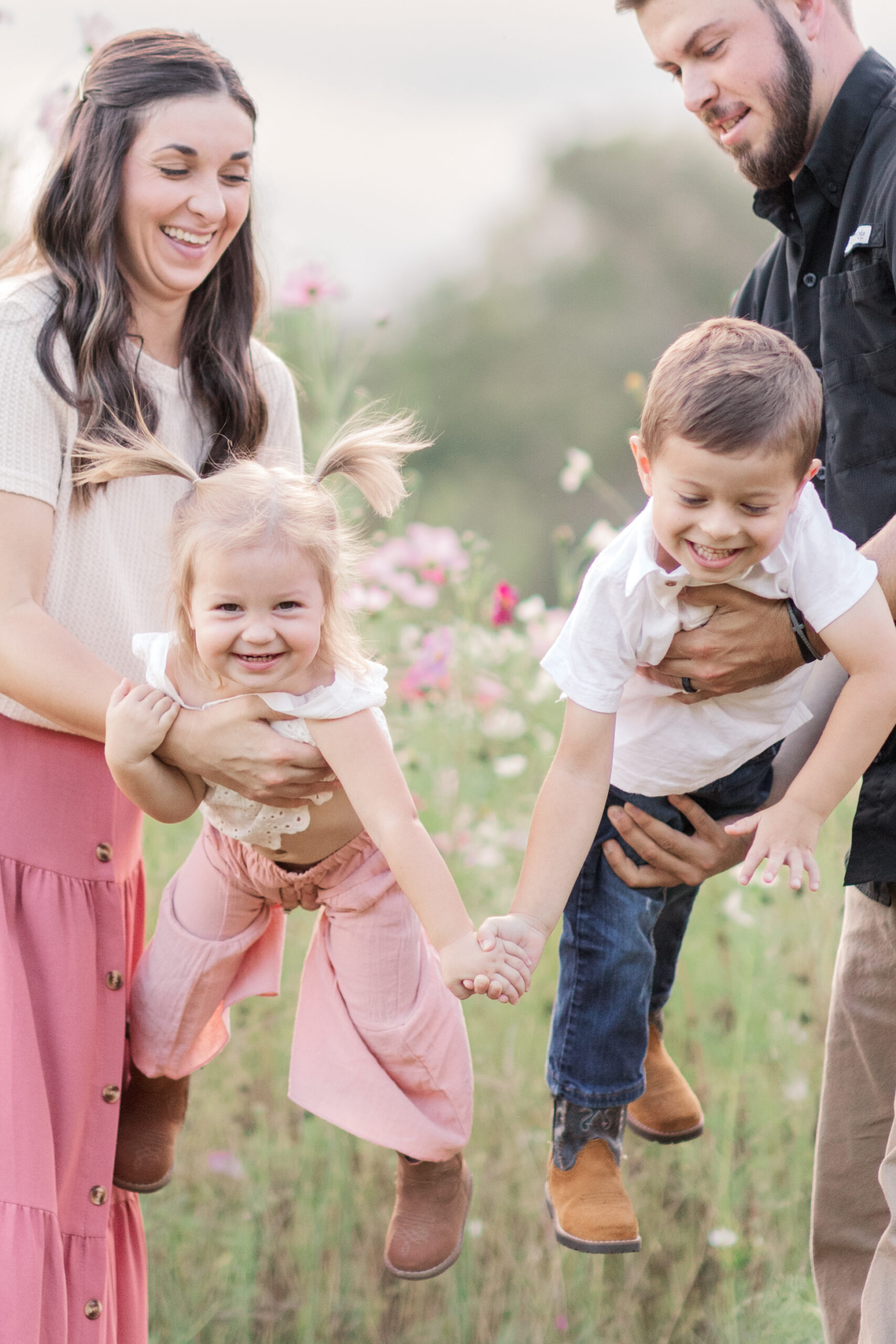 mom and dad making little girl and boy fly during their family photos in Taylorsville NC.