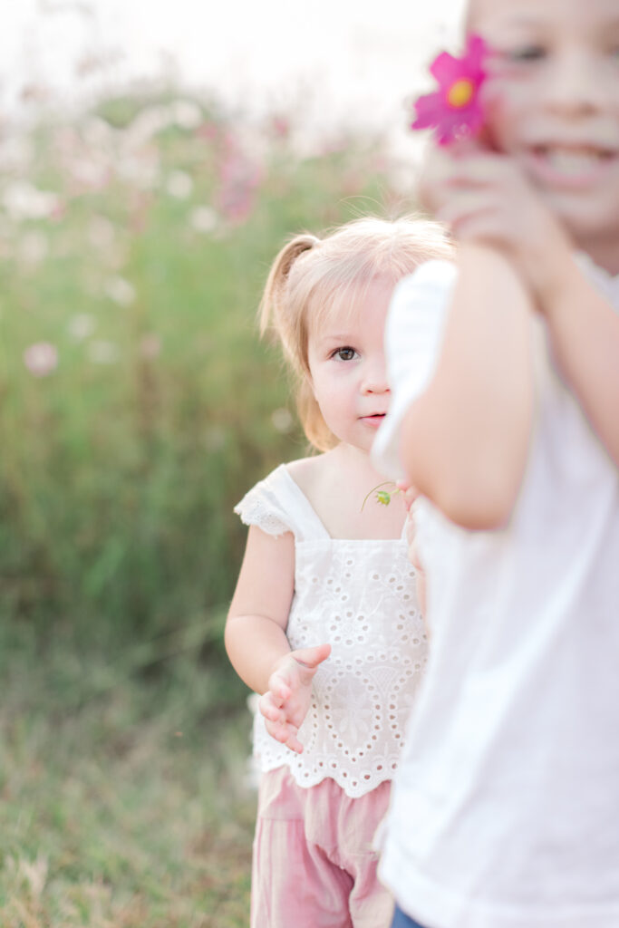 Little girl and boy showing me wildflowers being casual as they prepare for family photos in Taylorsville, NC> 
