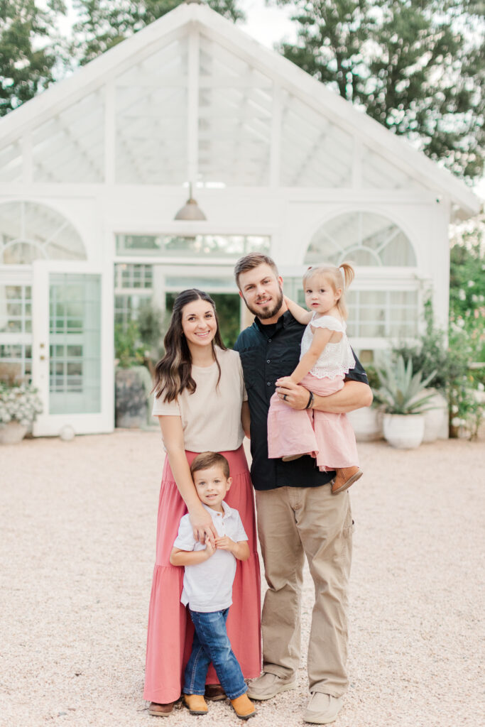 Family looking at camera in front of Fleurish Greenhouse. 