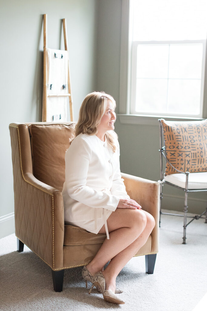 Woman in chair looking out the window during branding photo session with Hannah Elizabeth Photography. 